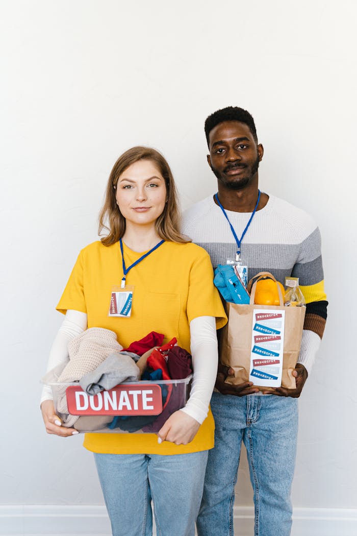 about-img A black man and caucasian woman holding donation boxes, highlighting diversity and charity.